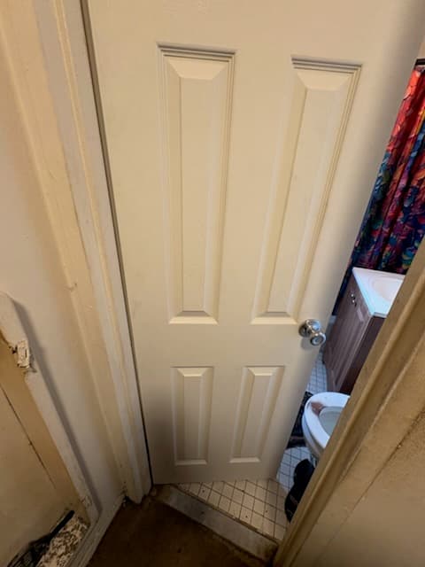After: the bedroom door in its opening, finished in white